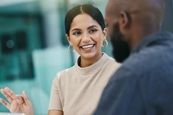 Une femme noire joyeuse conversant avec un homme.