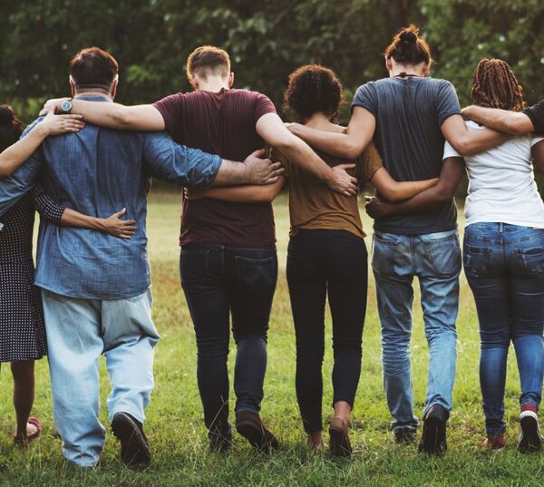 Six personnes bras dessus bras dessous qui s'éloignent. 