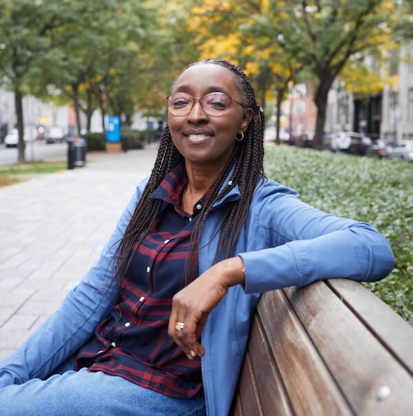 Femme noire assise sur un banc public